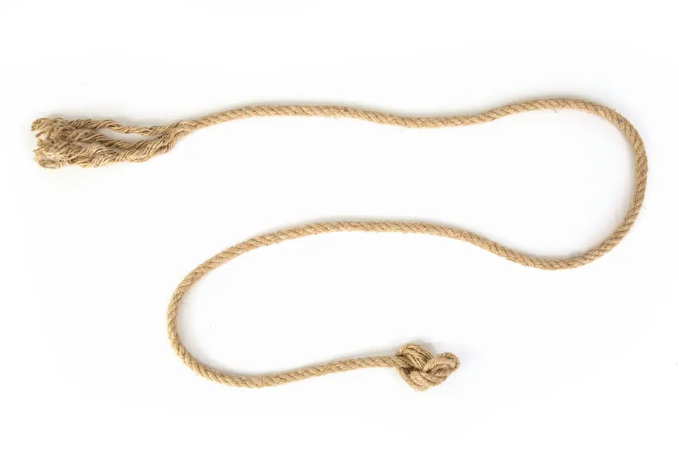 Une corde de chanvre dénouée, posée librement sur un fond blanc